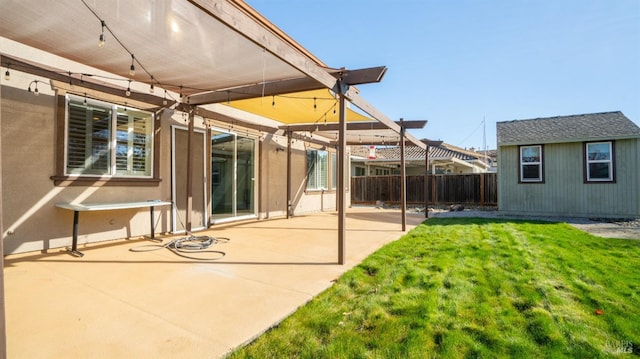 rear view of house with a yard, an outbuilding, and a patio area