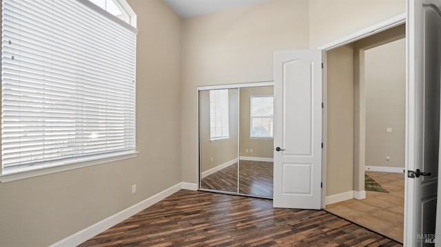 unfurnished bedroom featuring dark hardwood / wood-style flooring and a closet