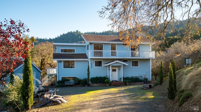 view of front of house with a balcony and a front lawn