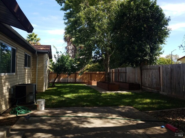 view of yard with a fenced backyard, cooling unit, and a patio