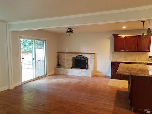 unfurnished living room with hardwood / wood-style floors and a brick fireplace