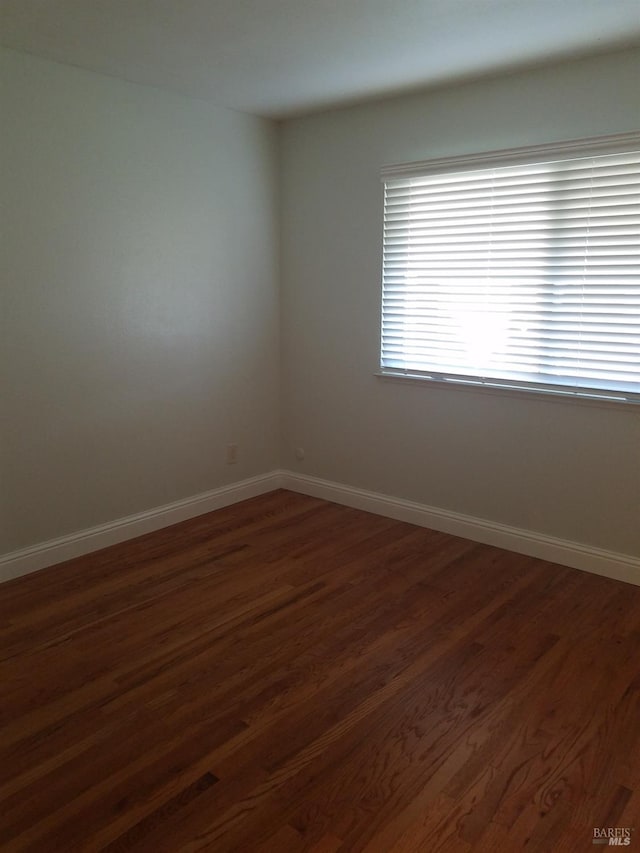 spare room featuring dark hardwood / wood-style floors