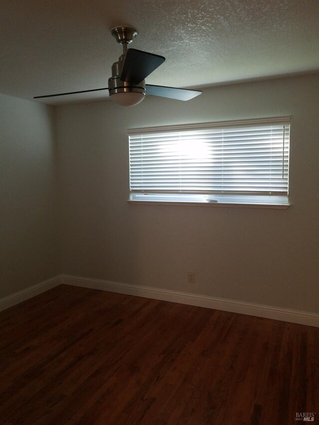 unfurnished room with ceiling fan, wood-type flooring, and a textured ceiling