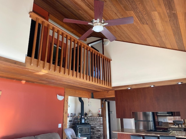 staircase featuring a wood stove, ceiling fan, and wood ceiling