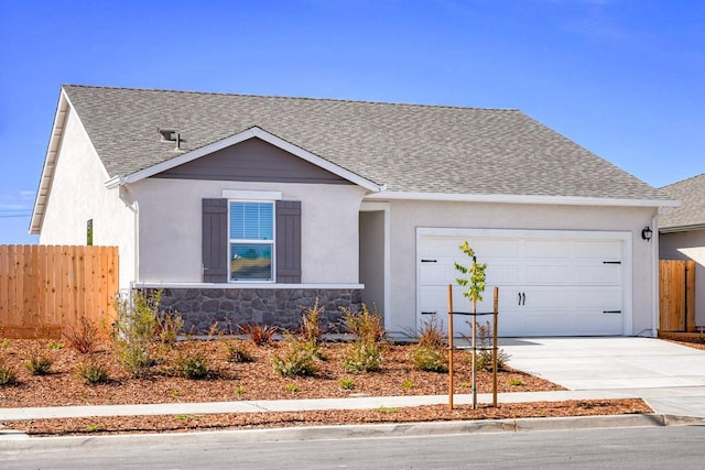 ranch-style home featuring roof with shingles, fence, concrete driveway, an attached garage, and stone siding