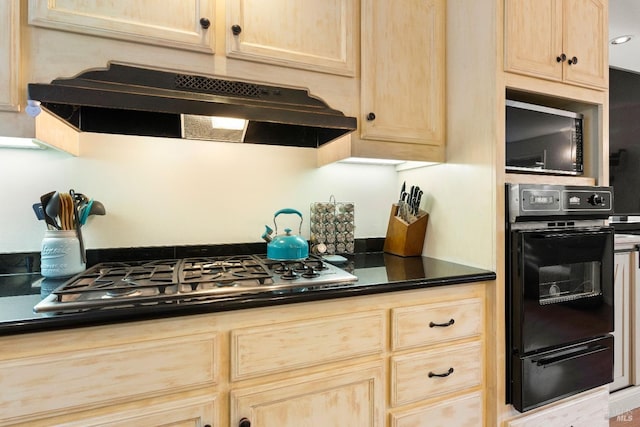 kitchen featuring black oven, light brown cabinetry, and gas cooktop