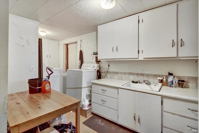 washroom featuring washer / clothes dryer, sink, and cabinets