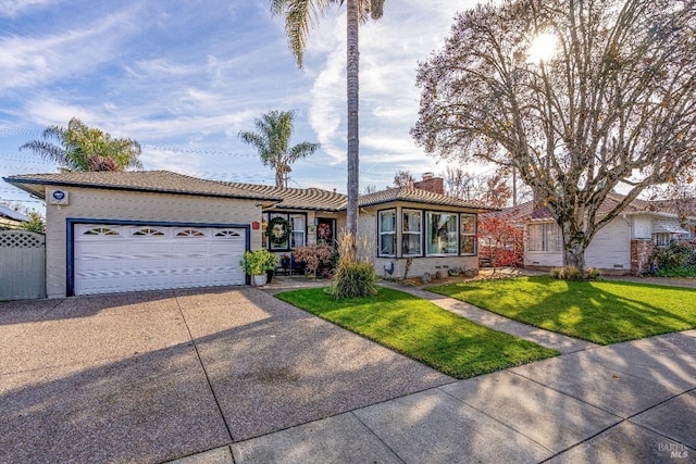 ranch-style home with a tile roof, a chimney, concrete driveway, an attached garage, and a front yard