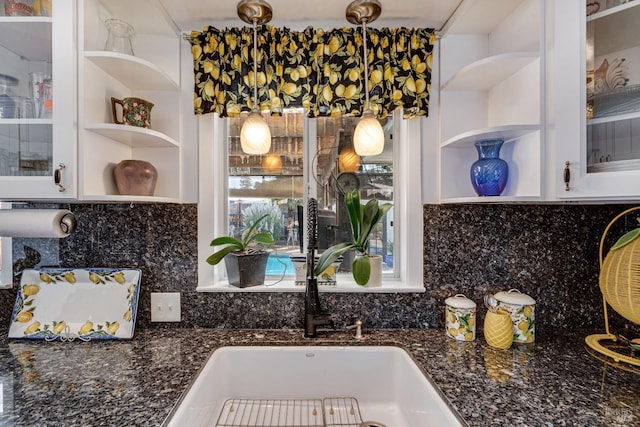 interior details featuring a sink, glass insert cabinets, open shelves, and decorative backsplash