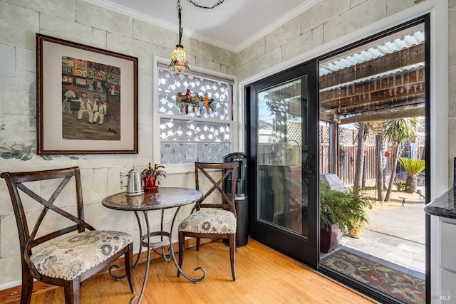 living area with a wealth of natural light, light wood-style flooring, and crown molding