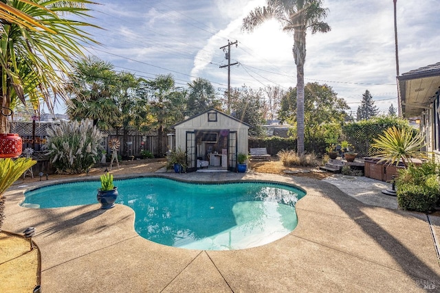 view of swimming pool featuring an outbuilding, a patio area, a fenced backyard, and a fenced in pool
