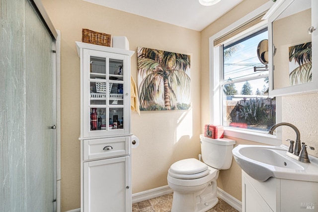 full bath with a shower with shower door, vanity, and baseboards