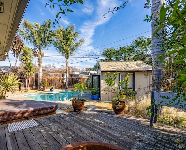 wooden terrace with a fenced in pool, an outdoor structure, and fence
