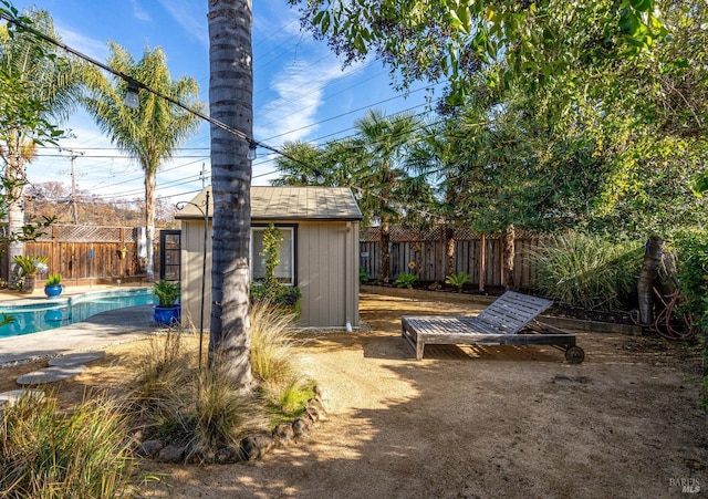 view of yard with an outbuilding, a fenced backyard, and a fenced in pool