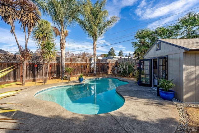 view of pool featuring a fenced in pool, a fenced backyard, an outdoor structure, and a patio