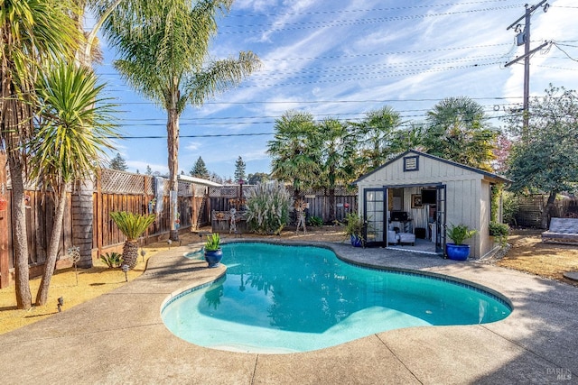 view of swimming pool with an exterior structure, an outbuilding, a fenced in pool, and a fenced backyard