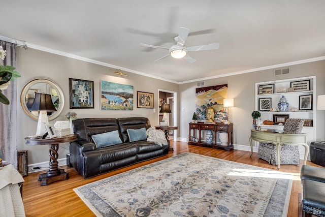 living area with crown molding, visible vents, ceiling fan, wood finished floors, and baseboards