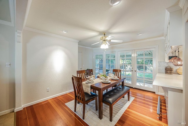 dining space featuring ceiling fan, crown molding, light hardwood / wood-style flooring, and french doors