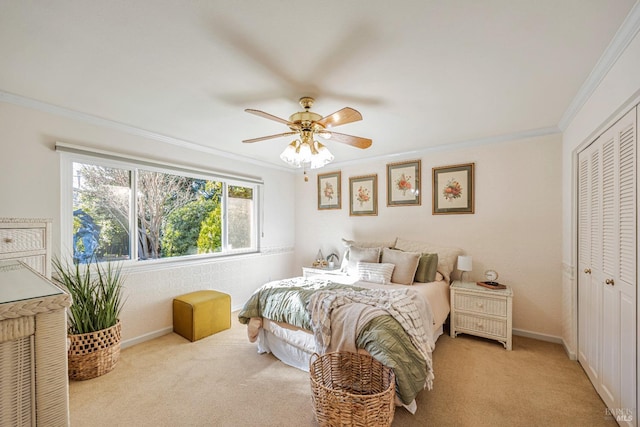 carpeted bedroom featuring a closet, ornamental molding, and ceiling fan