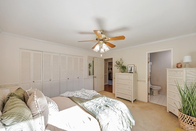 bedroom with ceiling fan, light colored carpet, ornamental molding, and connected bathroom