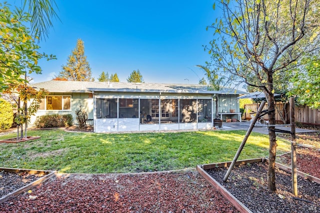 back of house with a yard and a sunroom