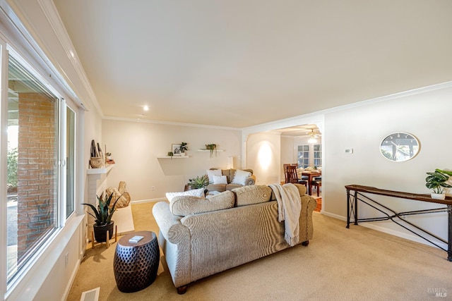 carpeted living room with crown molding, ceiling fan, and a healthy amount of sunlight