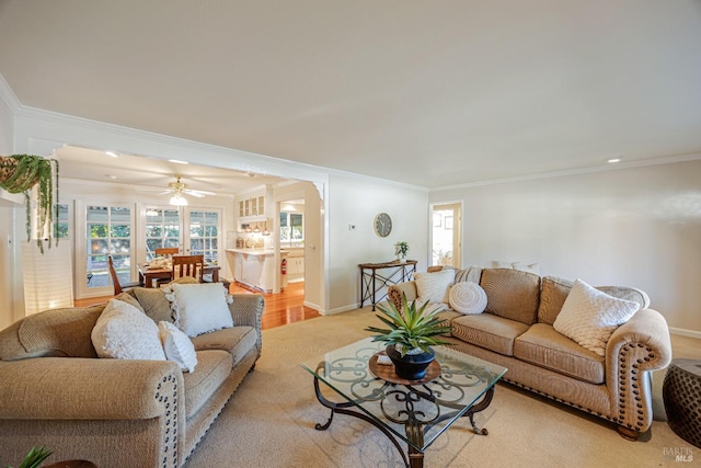 living room with light wood-type flooring, ceiling fan, and crown molding