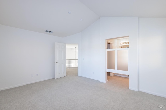 unfurnished bedroom with light carpet and lofted ceiling