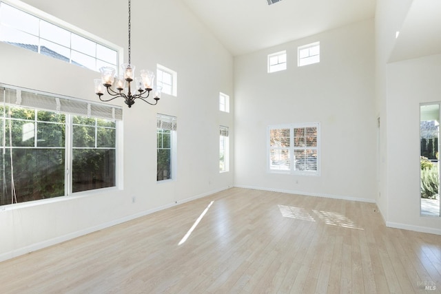 interior space featuring a chandelier, a high ceiling, basketball court, and light hardwood / wood-style flooring