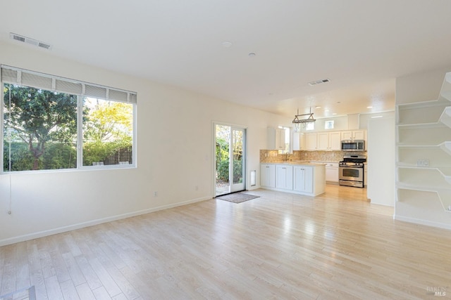 unfurnished living room featuring light hardwood / wood-style flooring and sink