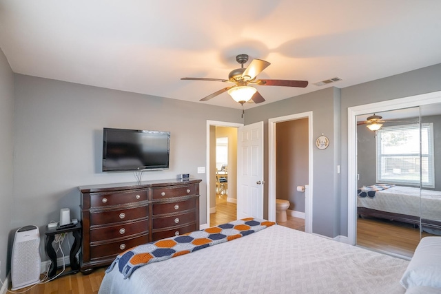 bedroom featuring connected bathroom, light hardwood / wood-style floors, a closet, and ceiling fan