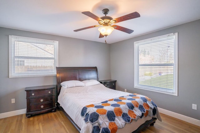 bedroom featuring multiple windows, ceiling fan, and light hardwood / wood-style floors