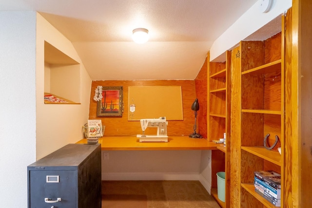 interior space with lofted ceiling, built in desk, built in features, and a textured ceiling