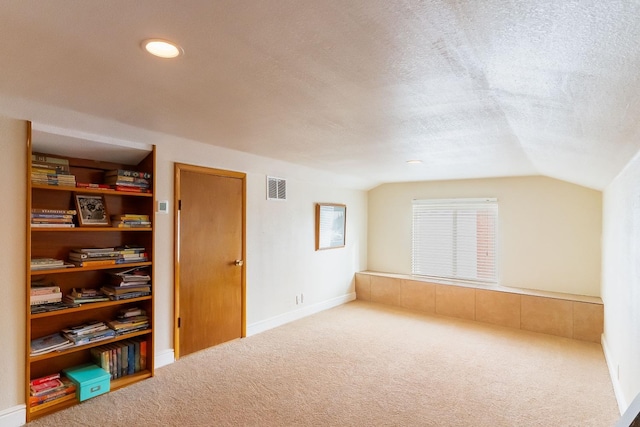 bonus room featuring vaulted ceiling, a textured ceiling, and carpet