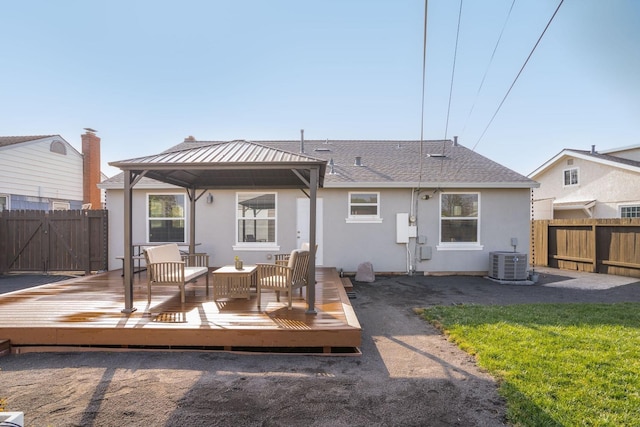 rear view of house with a deck, a yard, a gazebo, central AC, and an outdoor living space