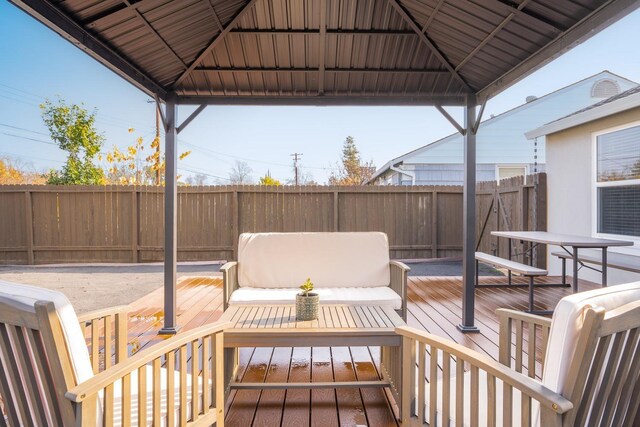 wooden terrace featuring a gazebo, an outdoor living space, and a yard