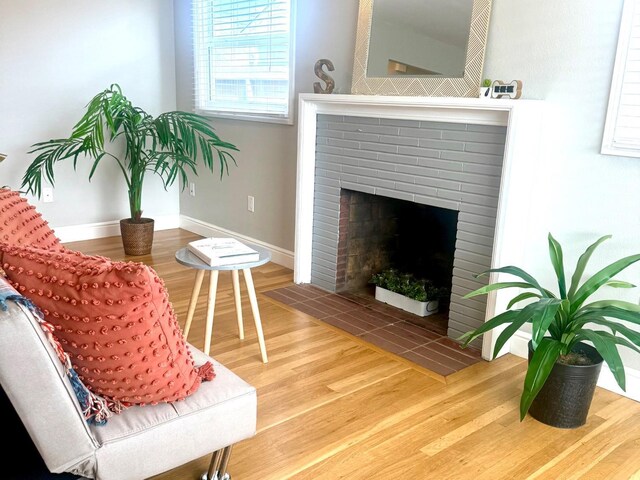 dining room with a brick fireplace and light wood-type flooring