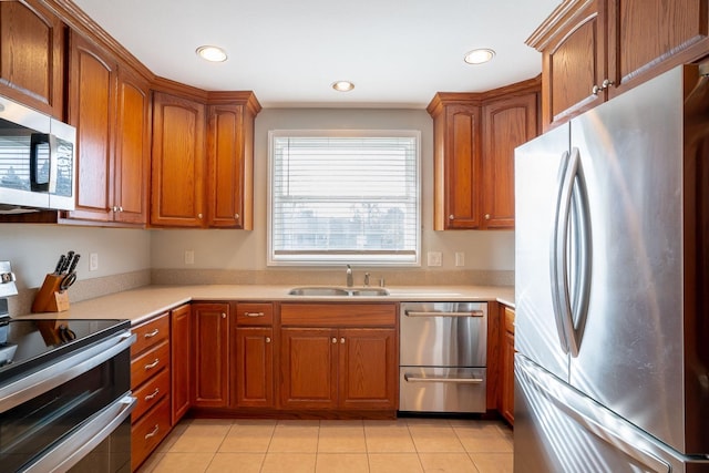 kitchen with sink, light tile patterned floors, and stainless steel appliances