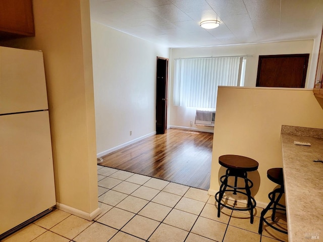 504 Low Gap Rd, Ukiah, CA 95482 - kitchen featuring freestanding refrigerator, light tile patterned flooring, a wall unit AC, and baseboards