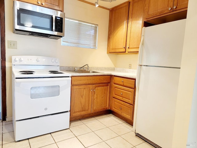 kitchen with sink, light tile patterned floors, and white appliances