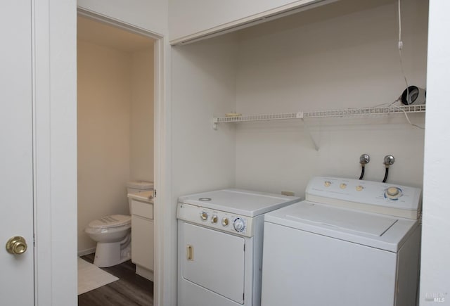 laundry room with dark wood-type flooring and washer and dryer