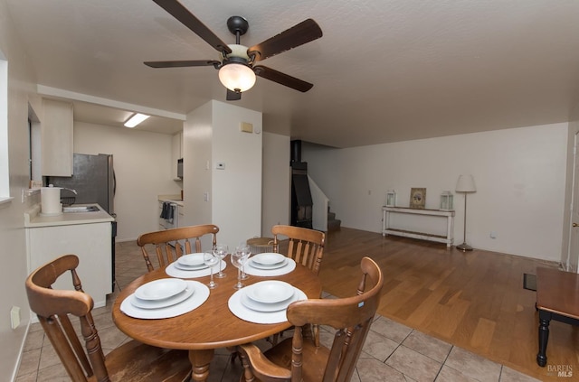 dining room with sink, light tile patterned floors, and ceiling fan