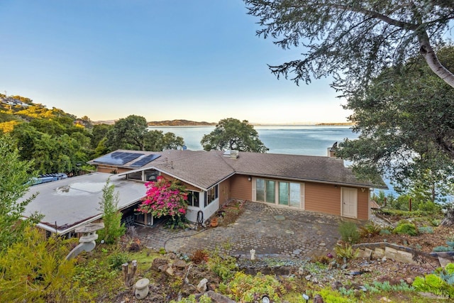 exterior space featuring solar panels and a water view