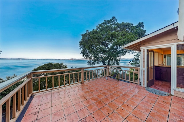 view of patio featuring a water view and a balcony