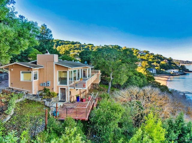 back of property with a balcony and a deck with water view