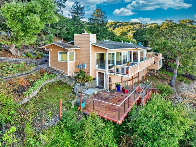 rear view of property with a balcony and a deck