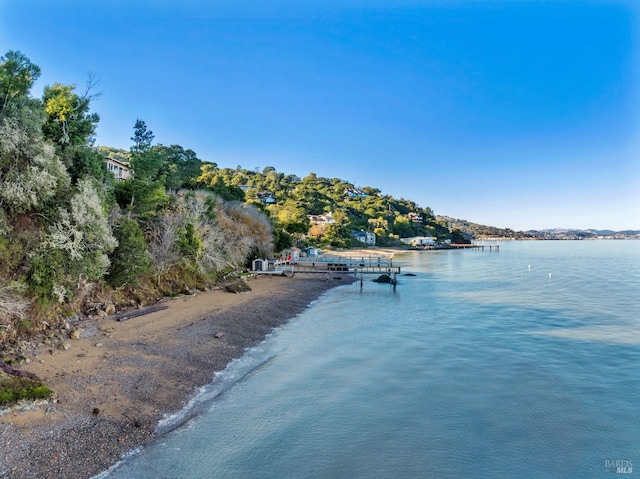 view of water feature featuring a view of the beach and a dock