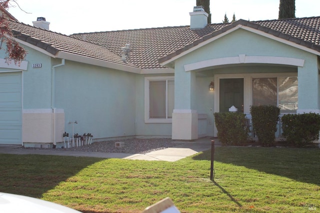 exterior space featuring a garage and a lawn