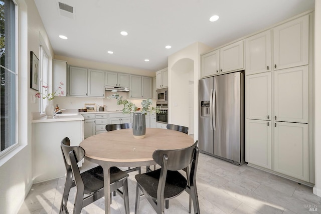 kitchen featuring recessed lighting, under cabinet range hood, a sink, light countertops, and black appliances