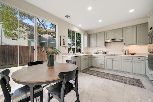 kitchen with recessed lighting, under cabinet range hood, stainless steel appliances, visible vents, and light countertops